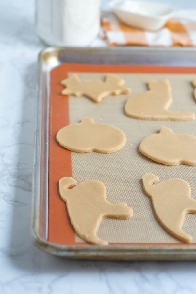 Cut-out sugar cookie shapes on a baking sheet.