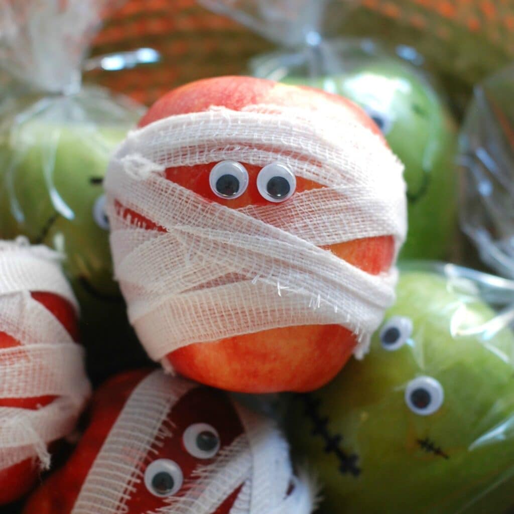 Apples wrapped in gauze with googly eyes to look like mummies.