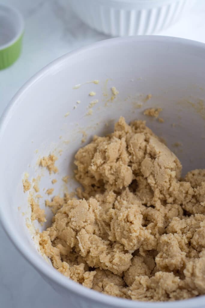 Dough for whole wheat Halloween cookies in a white mixing bowl.